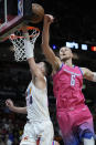 Washington Wizards center Kristaps Porzingis (6) swats away a dunk by Miami Heat guard Tyler Herro (14) during the first half of an NBA basketball game, Friday, Nov. 25, 2022, in Miami. (AP Photo/Wilfredo Lee)