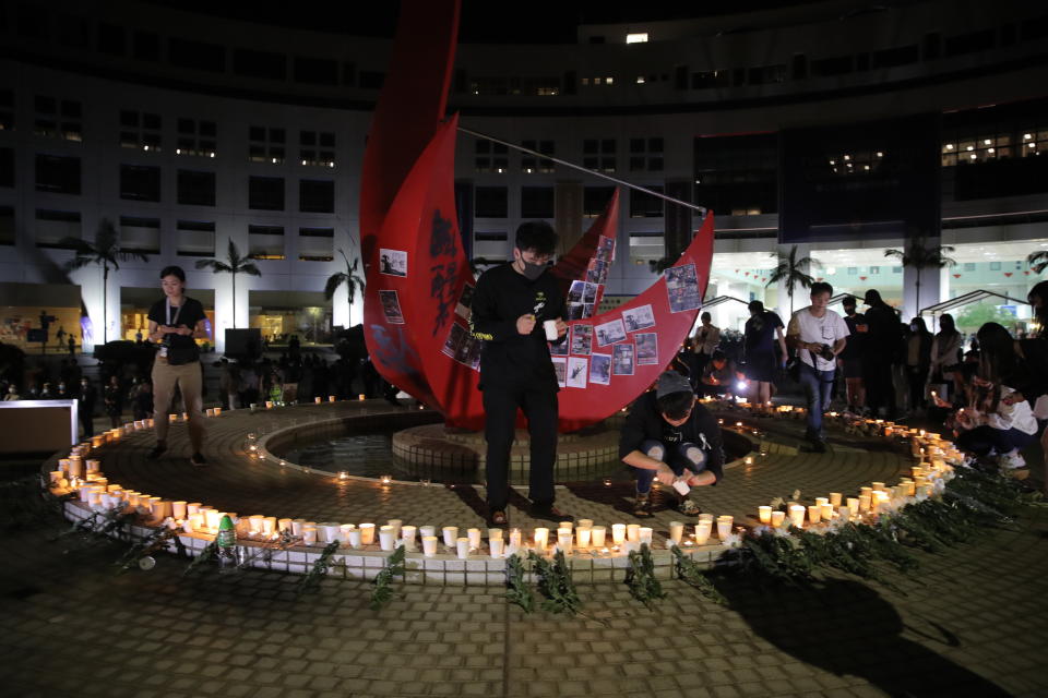 Protester light candles at a makeshift memorial at the University of Science and Technology for a student who died in Hong Kong on Friday, Nov. 8, 2019. Chow Tsz-Lok, a student from the University who fell off a parking garage after police fired tear gas during clashes with anti-government protesters died Friday, in a rare fatality after five months of unrest that intensified anger in the semi-autonomous Chinese territory. (AP Photo/Kin Cheung)