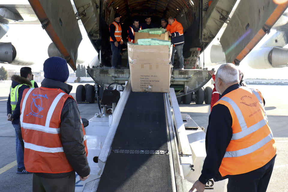 In this photo released by the official Syrian state news agency SANA, workers unload humanitarian aid sent from Arminia, for Syria following a devastating earthquake, at the airport in Aleppo, Syria, Thursday, Feb. 9, 2023. Rescuers pulled more survivors from beneath the rubble of collapsed buildings Thursday, but hopes were starting to fade of finding many more people alive more than three days after a catastrophic earthquake and series of aftershocks hit Turkey and Syria. (SANA via AP)