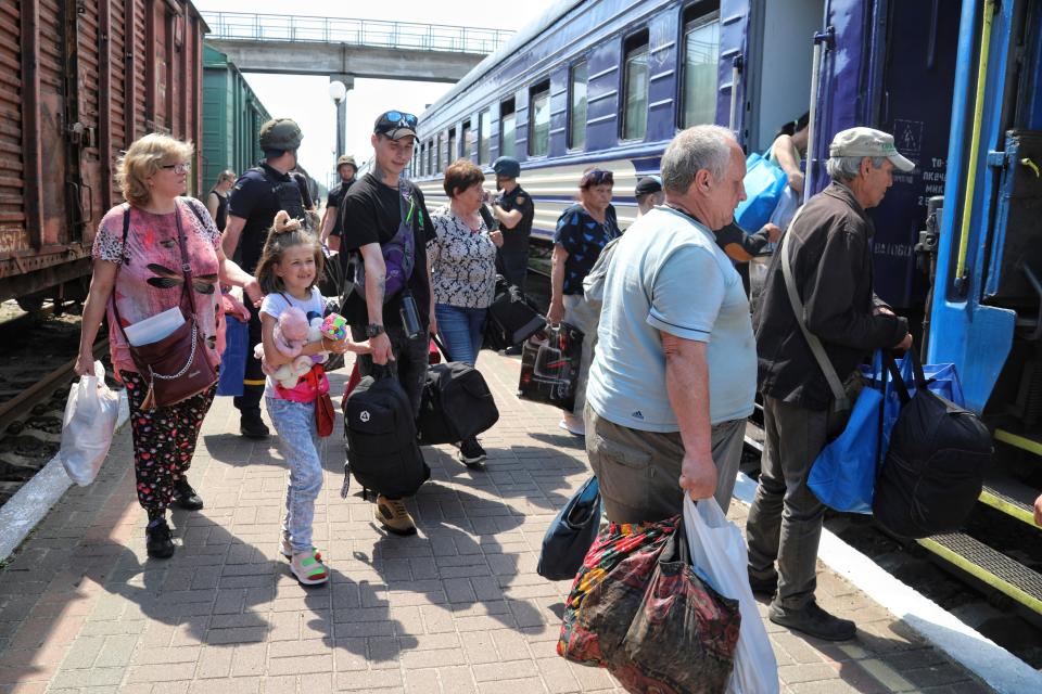 People try to board a train in Kherson (AP)