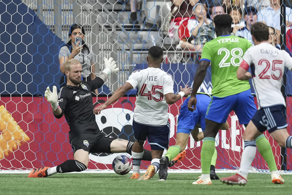 Vancouver Whitecaps' Pedro Vite (45) scores against Seattle Sounders goalkeeper Stefan Frei, back left, during the first half of an MLS soccer match in Vancouver, British Columbia on Saturday, May 20, 2023. (Darryl Dyck/The Canadian Press via AP)