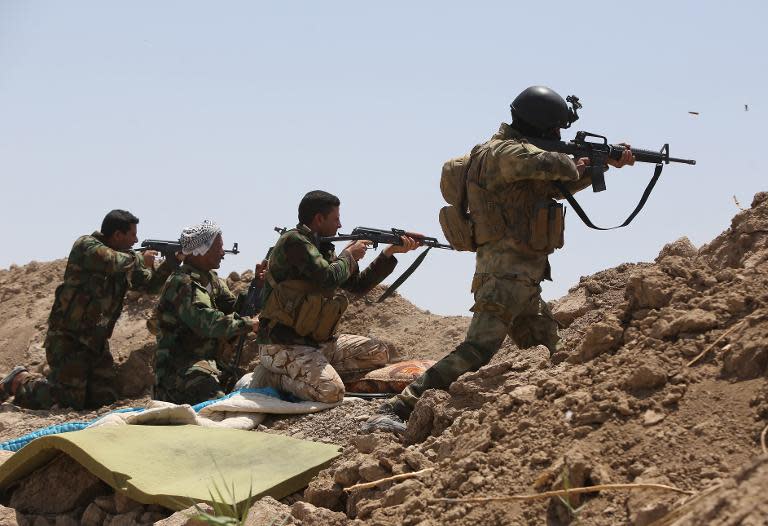 Iraqi soldiers and Shiite fighters from the popular committees fire towards Islamic State (IS) positions in the Garma district of Anbar province on May 19, 2015