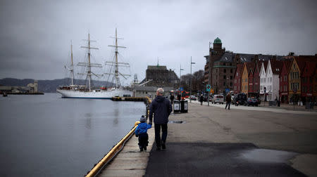 A man walks with a child near the marina in downtown Bergen, southwestern Norway. REUTERS/Stoyan Nenov