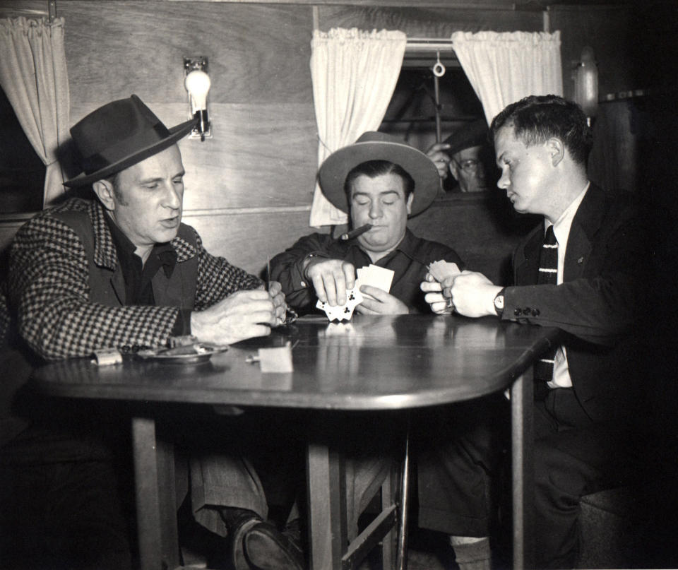 FILE - In this circa 1945 file photo provided by Associated Press reporter Bob Thomas, right, plays poker with legendary comedians Bud Abbott, left, and Lou Costello, during an interview. When Thomas began writing a Hollywood column for The AP in 1944, there were 500 journalists covering the movie scene. Fresh, newsy interviews were hard to come by, so he began writing "participation stories." Thomas died of age-related illnesses Friday, March 14, 2014 at his Encino, Calif., home, his daughter Janet Thomas said. He was 92. (AP Photo/Courtesy Bob Thomas, file)