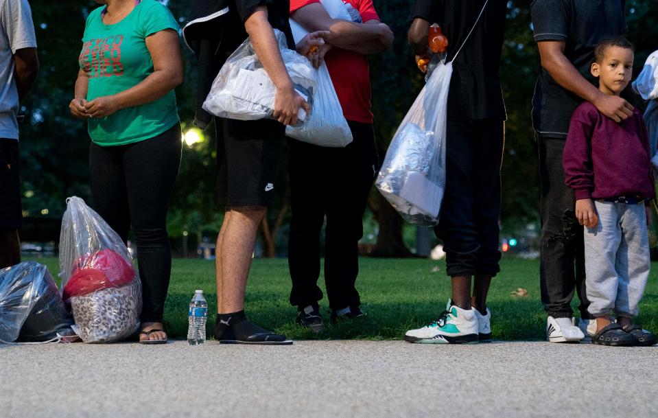 Migrants, who boarded a bus in Texas, listen to volunteers offering assistance after being dropped off within view of the US Capitol building in Washington, DC, on August 11, 2022. - Since April, Texas Governor Greg Abbott has ordered buses to carry thousands of migrants from Texas to Washington, DC, and New York City to highlight criticisms of US President Joe Biden's border policy.