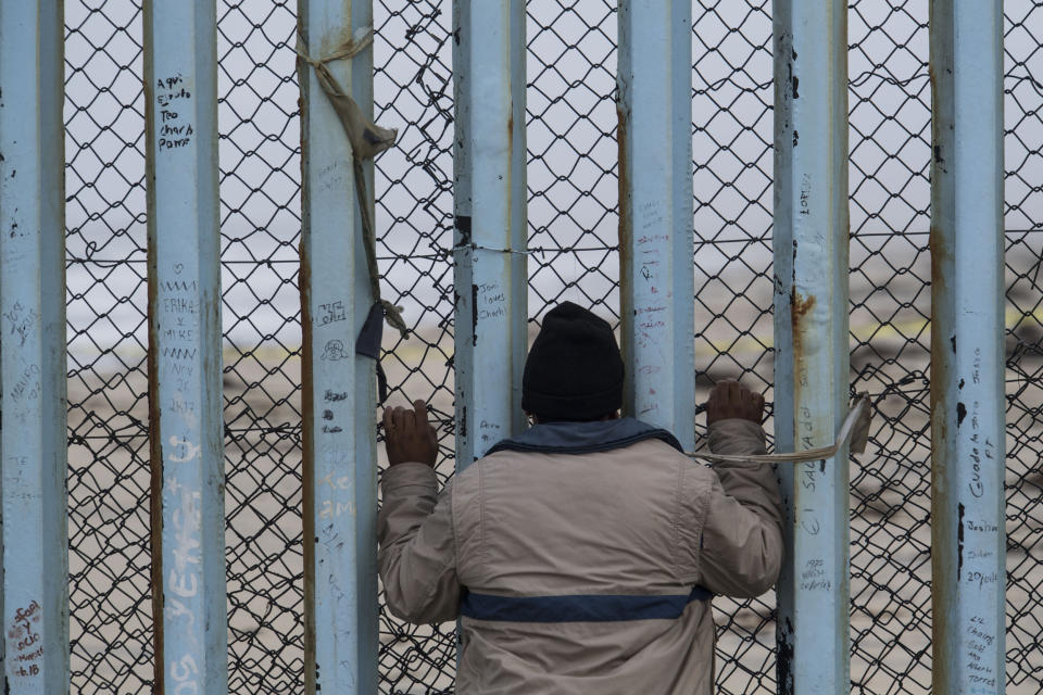 William Rafael Carranza Martinez looks through the border wall before marrying his partner at the beginning of the March Without Borders at Friendship Park.