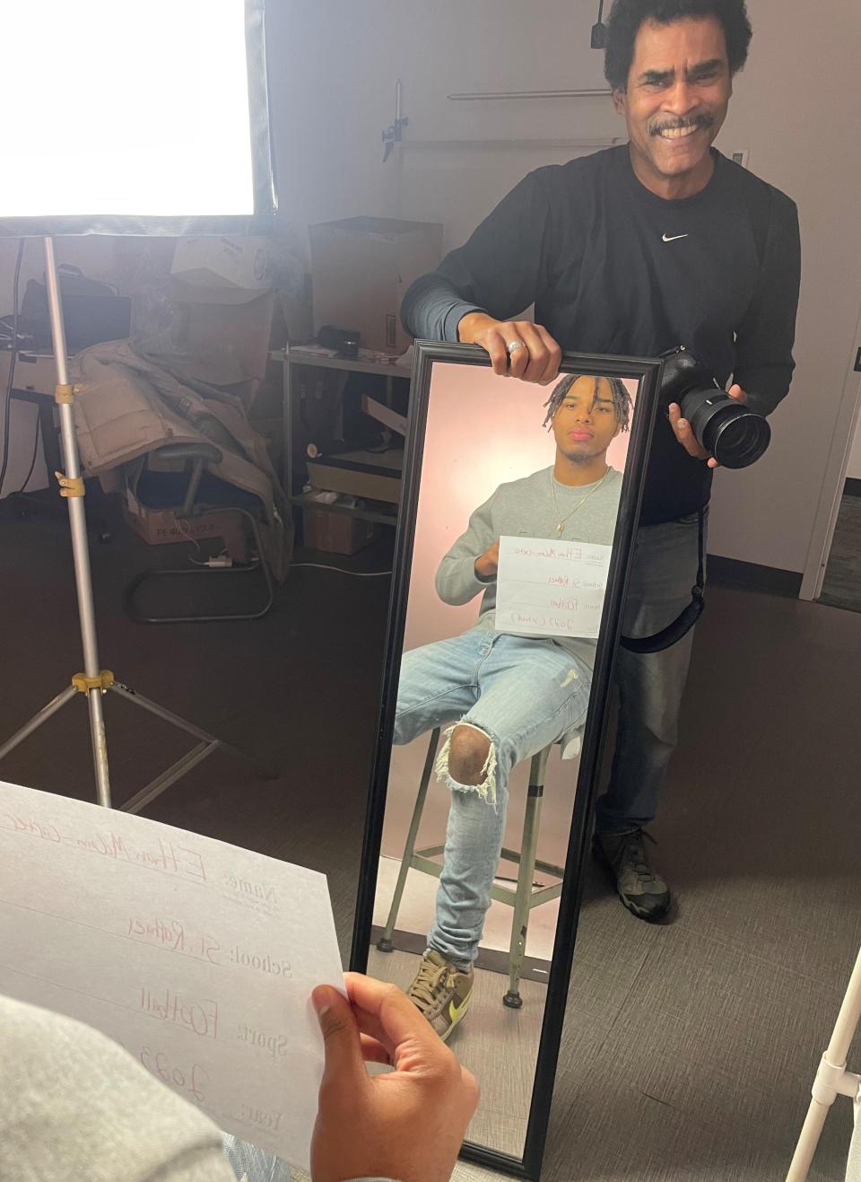 Providence Journal photographer Kris Craig holds a mirror up for St. Raphael football star Ethan McCann-Carter as part of a Journal All-States photo shoot in the Fountain Street studio.
