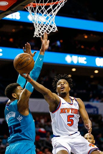 Knicks guard Dennis Smith Jr. drives to the basket past Hornets forward P.J. Washington on Wednesday in Charlotte. The Hornets won 107-101.