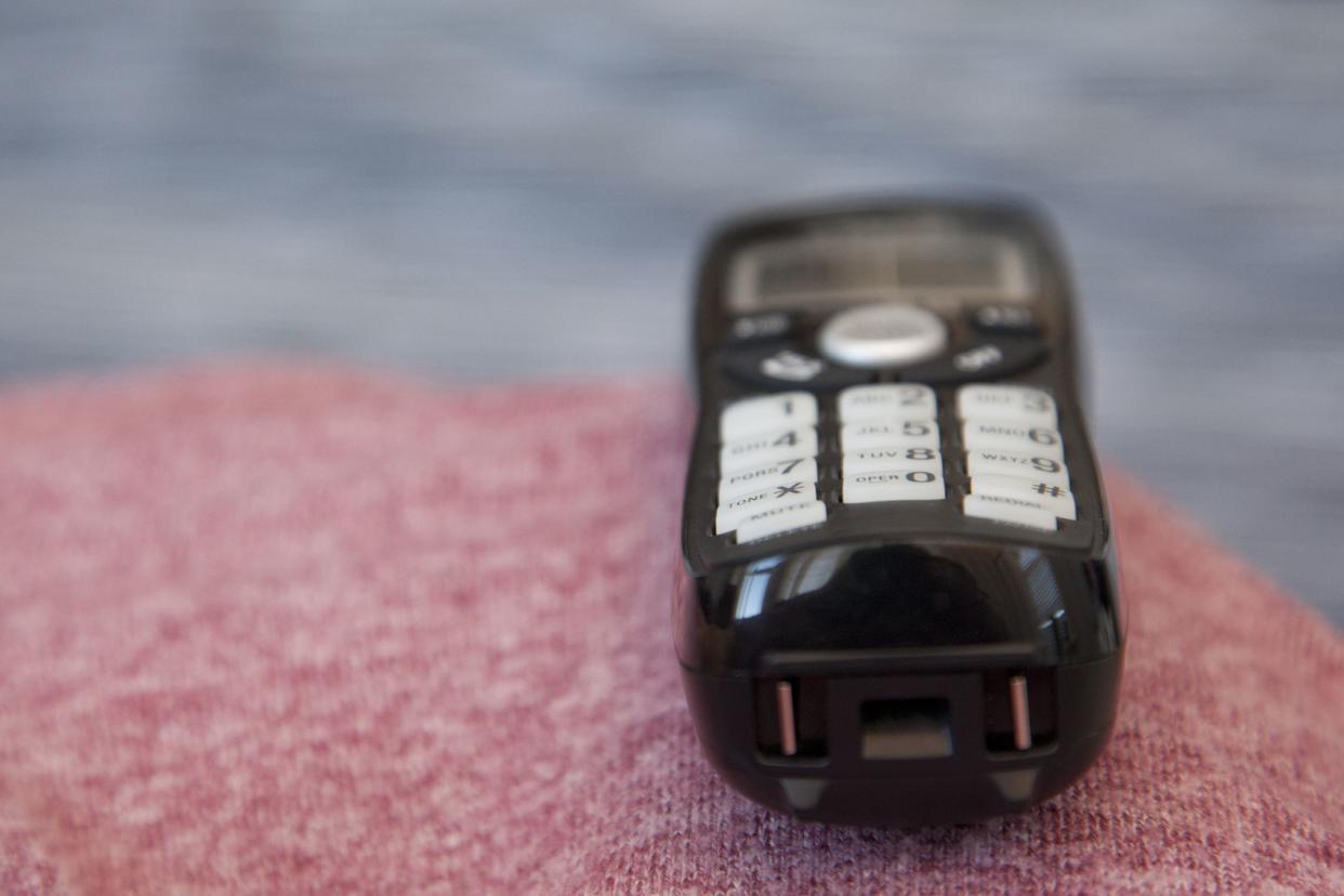 A black cordless phone sits waiting to be picked up or dialed