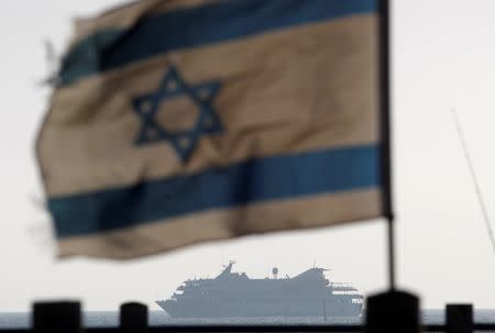 An Israeli flag flutters in the wind as a naval vessel (not seen) escorts the Mavi Marmara, a Gaza-bound ship that was raided by Israeli marines, to the Ashdod port May 31, 2010. REUTERS/Amir Cohen/File Photo