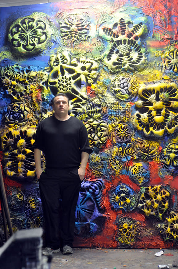 Artist Ioan Florea stands in front of one of his giant paintings created using 3D-printing techniques that give the finished product both tactile and visual elements.