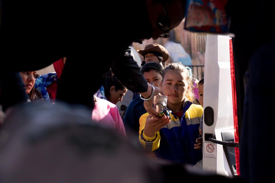 Mi Cabaña Mexican Restaurant brings juice, water, hot chocolate and burritos to Venezuelan migrants staying in the streets of El Paso in front of Sacred Heart Church, on Wednesday, Dec. 21, 2022, after crossing into the U.S.