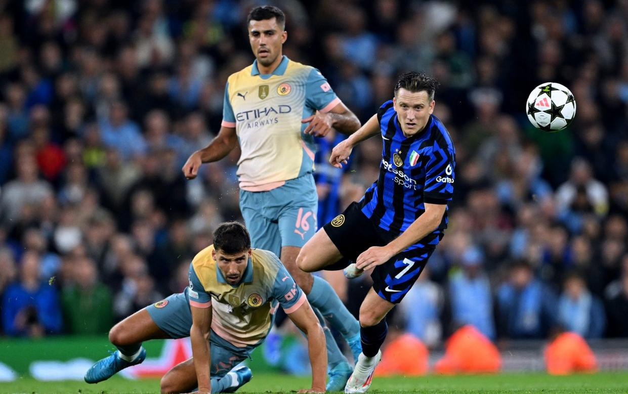 Piotr Zielinski of FC Internazionale is challenged by Ruben Dias of Manchester City