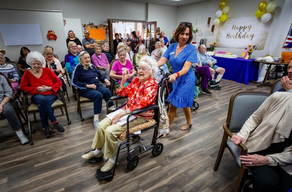 Velma Thompson greets fellow residents of Lake Morton Senior Living on Tuesday as she arrives for a surprise birthday party. Thompson, the oldest resident of the facility, turned 105 on Tuesday.