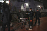 Paramedics carry the body of a crew member of a ship, on the northeastern Aegean Sea island of Lesbos, Greece, Sunday, Nov. 26, 2023. A cargo ship sank off the Greek island of Lesbos early Sunday, leaving 13 crew members missing and one rescued, authorities said. The Raptor, registered in the Comoros, was on its way to Istanbul from Alexandria, Egypt, carrying 6,000 tons of salt, the coast guard said. It had a crew of 14, including eight Egyptians, four Indians and two Syrians, the coast guard said.(AP Photo/Panagiotis Balaskas)