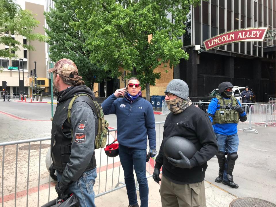 A small group of men in tactical gear arrive to a Reno Black Lives Matter peace vigil with Joey Gilbert, center on phone, a local lawyer who sued the state over the use of chloroquine for the coronavirus. They said they don’t believe the police did enough to protect the city and were at the peace vigil “in support” June 7, 2020.