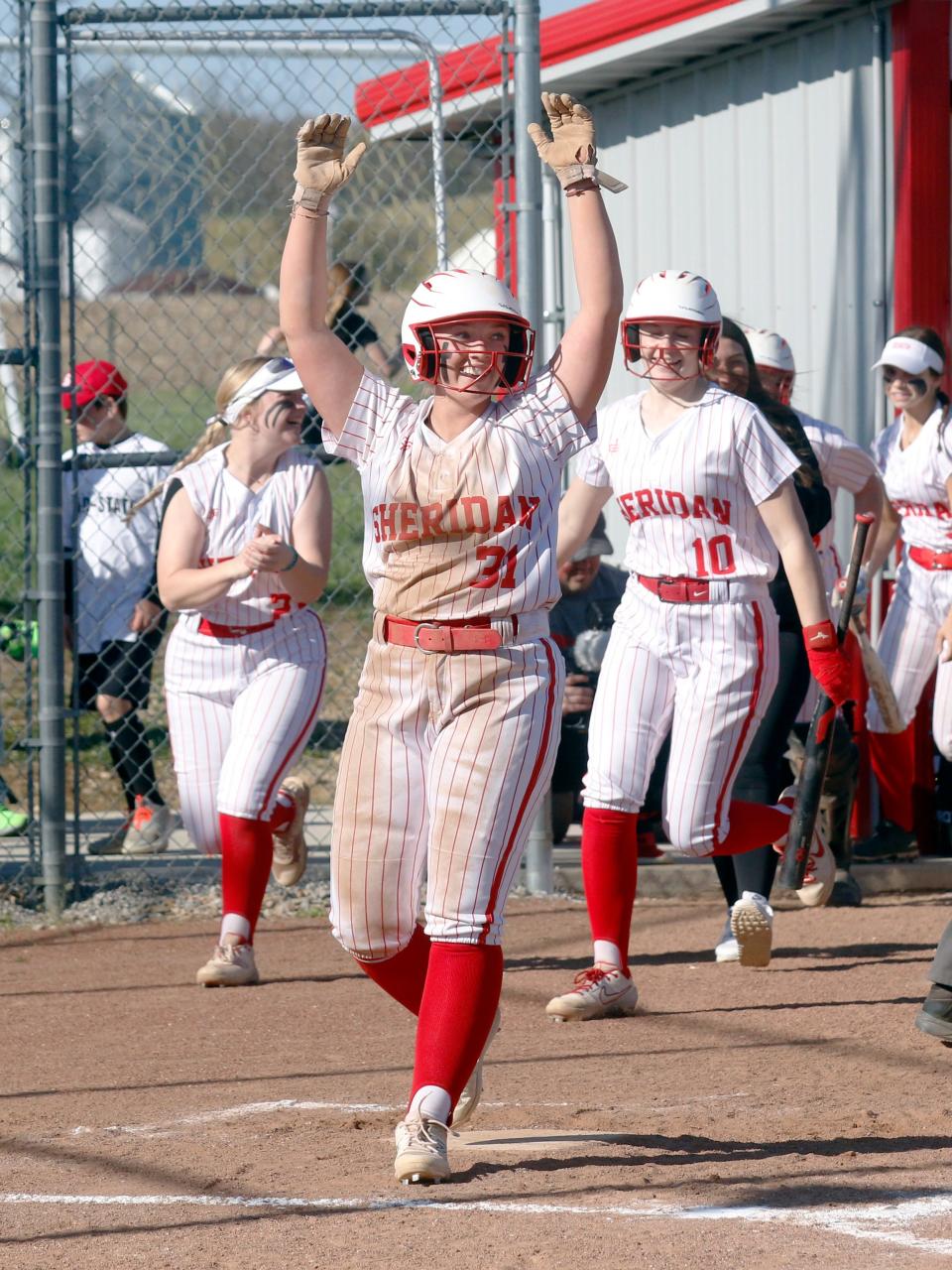 Avery Mueller celebrates after Cora Hall's go-ahead two-run homer in the third innind of Sheridan's 5-2 win against visiting Tri-Valley on Monday in Thornville.