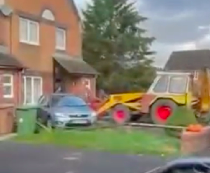 The JCB rammed into a car and porch of the house in Blackwood, south Wales. (Wales News Service)