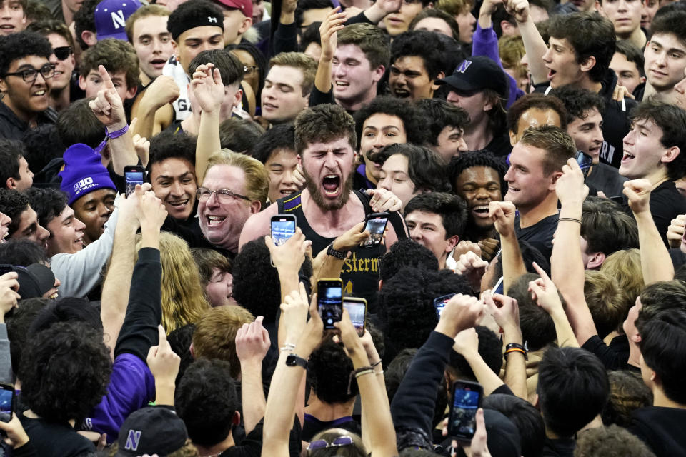 Northwestern center Matthew Nicholson, center, celebrates with fans after Northwestern defeated Purdue 64-58 in an NCAA college basketball game in Evanston, Ill., Sunday, Feb. 12, 2023. (AP Photo/Nam Y. Huh)