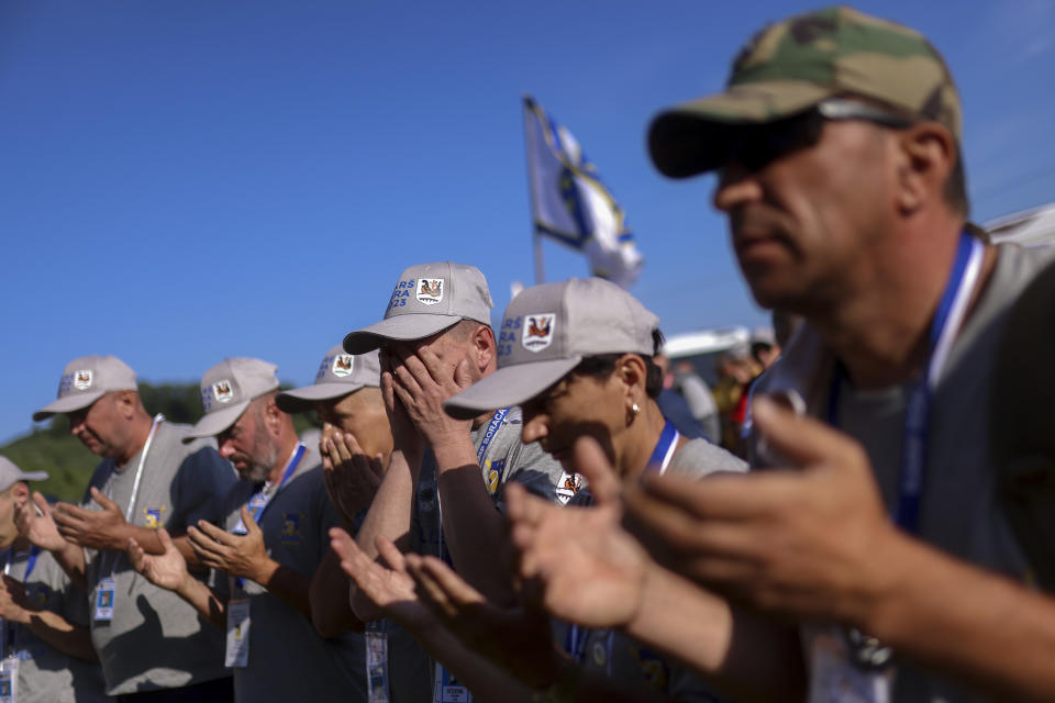 Bosnian Muslim men pray before the start of the "March of Peace", march to remember the 1995 Srebrenica massacre, in Nezuk, Bosnia, Saturday, July 8, 2023. A solemn peace march started on Saturday through forests in eastern Bosnia in memory of the 1995 Srebrenica massacre, Europe's only acknowledged genocide since World War II. The 100-kilometre (60-mile) march traces a route taken by Bosniak men and boys as they tried to flee Srebrenica after it was captured by Bosnian Serb forces in the closing days of the country's interethnic war in the 1990s. (AP Photo/Armin Durgut)