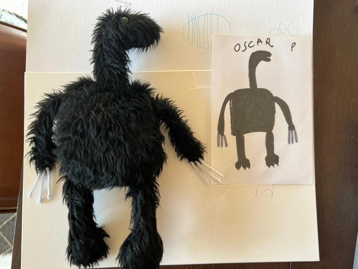 a drawing of a monster and a toy that looks just like it beside it