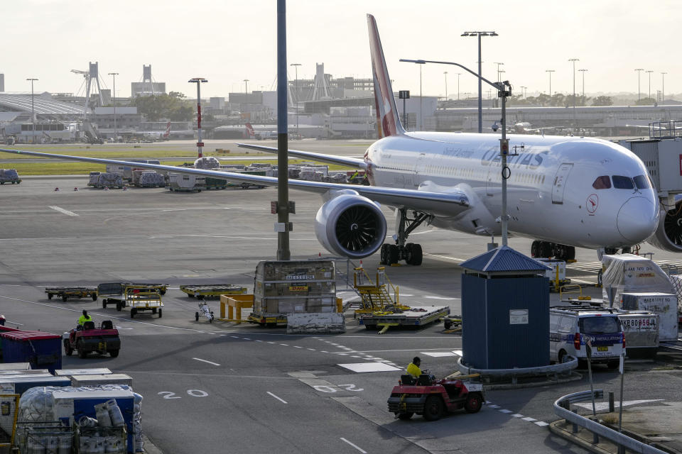 FILE - Ground crew drive their vehicles on the tarmac in the early morning at Sydney Airport, Monday, Nov. 29, 2021. Australia will open its borders to all vaccinated tourists and business travelers from Feb. 21 in a further relaxation of pandemic restrictions announced Monday, Feb. 7, 2022. (AP Photo/Mark Baker, File)