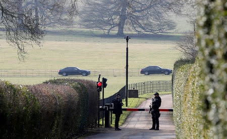 Armed police officers man the entrance to Chequers, the official country residence of the Prime Minister, as in the background official cars make they way towards the house near Aylesbury, Britain, February 22, 2018. REUTERS/Darren Staples