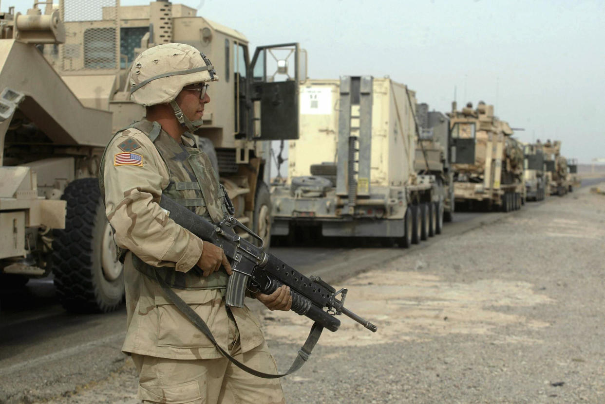 AL-SAD, IRAQ:  A US soldier stands guard in front of a convoy waiting to defuse an explosive device on the road leading to al-Sad, 150 kms north of Baghdad, 08 November 2003. The device was discovered by a Kiowa helicopter escorting the convoy.  AFP PHOTO/MARWAN NAAMANI  (Photo credit should read MARWAN NAAMANI/AFP via Getty Images)