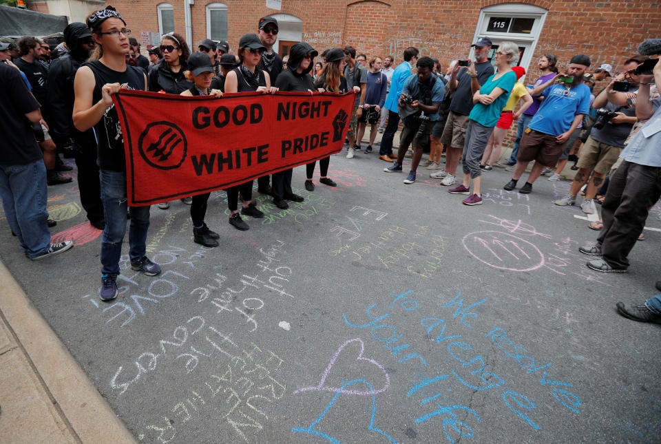 <p>A group wearing anti-fascist labels visits the site where Heather Heyer was killed during the 2017 Charlottesville “Unite the Right” protests in Charlottesville, Va., Aug. 11, 2018. (Photo: Brian Snyder/Reuters) </p>