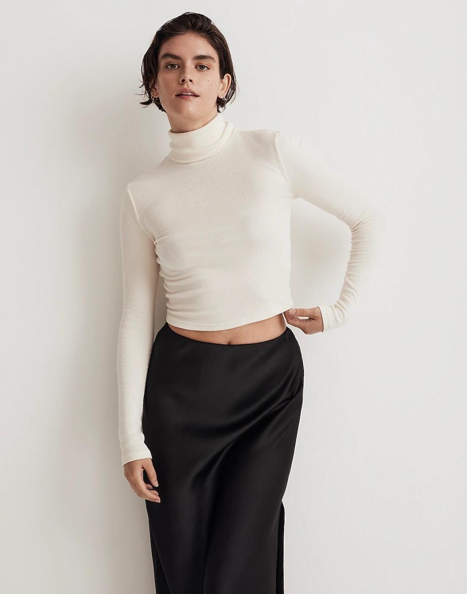 model wearing white cropped turtleneck with black silk skirt