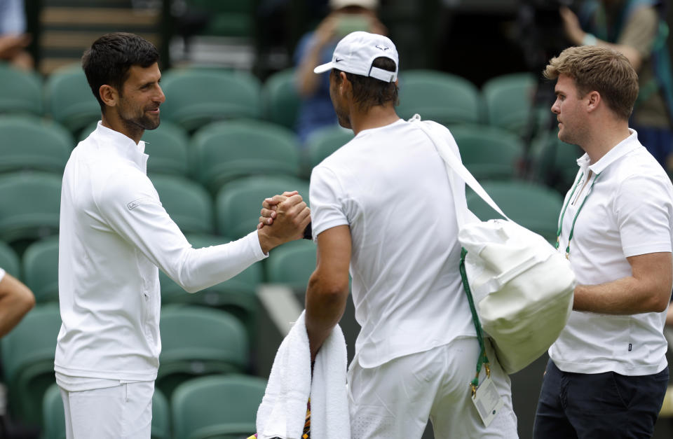 Nadal y Djokovic se saludan durante un entrenamiento en Wimbledon. (Foto: Steven Paston / PA Images / Getty Images).