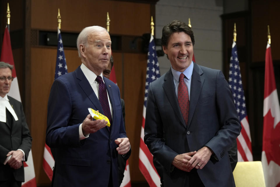 Prime Minister Justin Trudeau looks on as U.S. President Joe Biden holds a Canadian-made chocolate bar during a ceremony at Parliament Hill, in Ottawa, Canada, on Friday, March 24, 2023. (Adrian Wyld/The Canadian Press via AP)