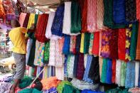 A vendor arranges lace materials for display at his stall in Balogun market in Nigeria's commercial capital, Lagos