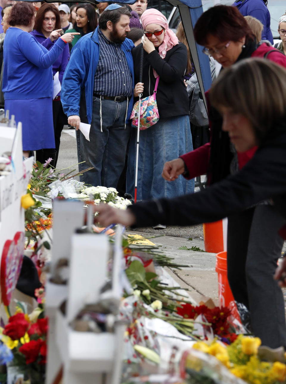 People pay their respects Thursday, Nov. 1, 2018, at a makeshift memorial outside the Tree of Life Synagogue to the 11 people killed Oct 27, 2018 while worshipping in the Squirrel Hill neighborhood of Pittsburgh. (AP Photo/Gene J. Puskar)