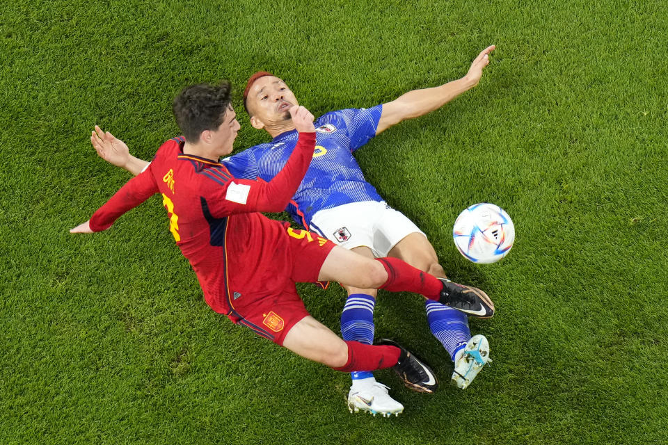 Japan's Yuto Nagatomo vies for the ball with Spain's Gavi, left, during the World Cup group E soccer match between Japan and Spain, at the Khalifa International Stadium in Doha, Qatar, Thursday, Dec. 1, 2022. (AP Photo/Petr David Josek)