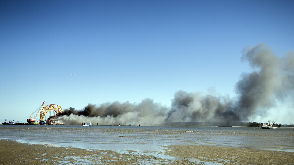 Fire fighters spray water into the cut away mid-section of the cargo vessel Golden Ray, Friday, May 14, 2021, Brunswick, Ga. The Golden Ray had roughly 4,200 vehicles in its cargo decks when it capsized off St. Simons Island on Sept. 8, 2019. Crews have used a giant gantry crane to carve the ship into eight giant chunks, then carry each section away by barge. (AP Photo/Stephen B. Morton)