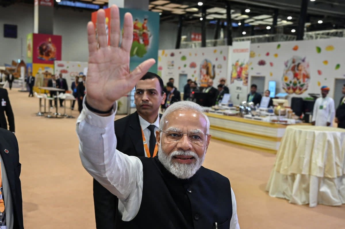 India's Prime Minister Narendra Modi (C) waves to the media during his visit to the International media centre, at the G20 summit venue (AFP via Getty Images)