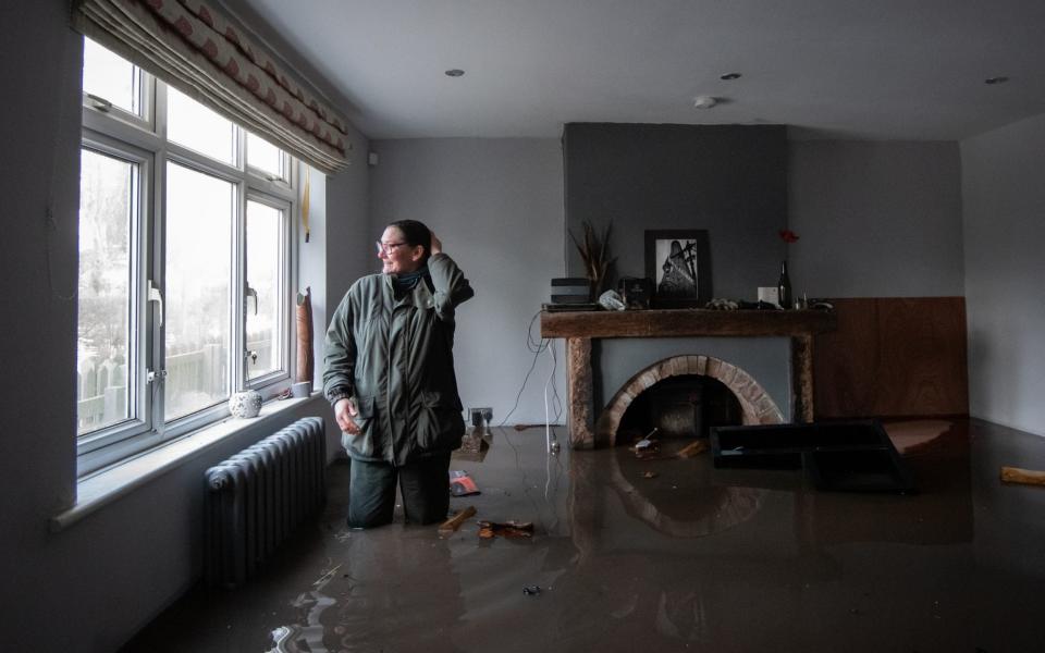 Gabrielle Burns-Smith looks out from her flooded home on the outskirts of Lymm in Cheshire -  Joe Giddens/PA