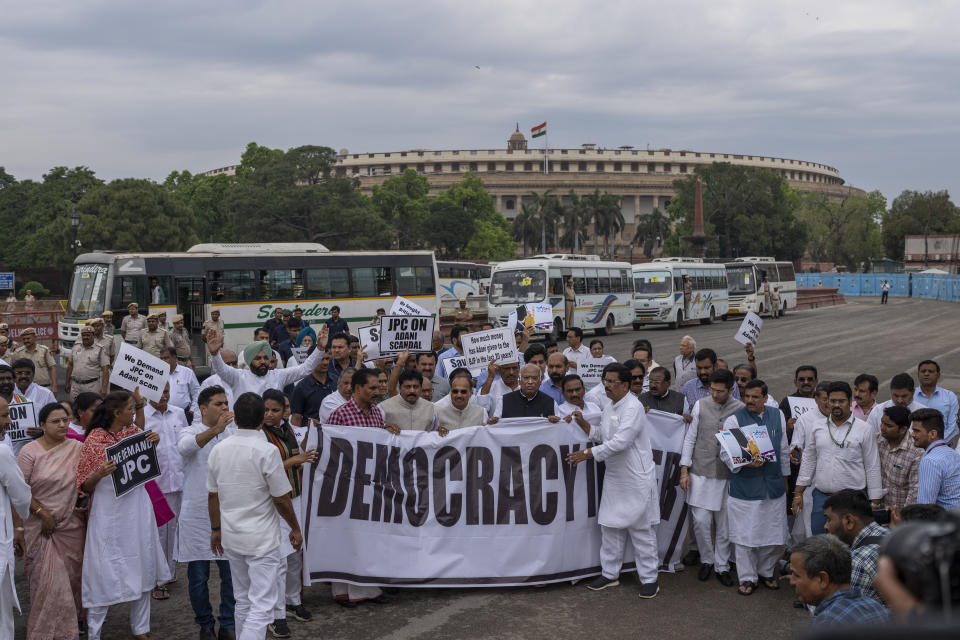 Lawmakers from India's opposition Congress and other parties hold a banner as they march against the Narendra Modi-led government alleging that Indian democracy is in danger, during a protest outside India's parliament in New Delhi, India, Friday, March 24, 2023. Key Indian opposition Congress party leader Rahul Gandhi lost his parliamentary seat as he was disqualified following his conviction by a court that found him of guilty of defamation over his remarks about Prime Minister Narendra Modi's surname, a parliamentary notification said on Friday. (AP Photo/Altaf Qadri)