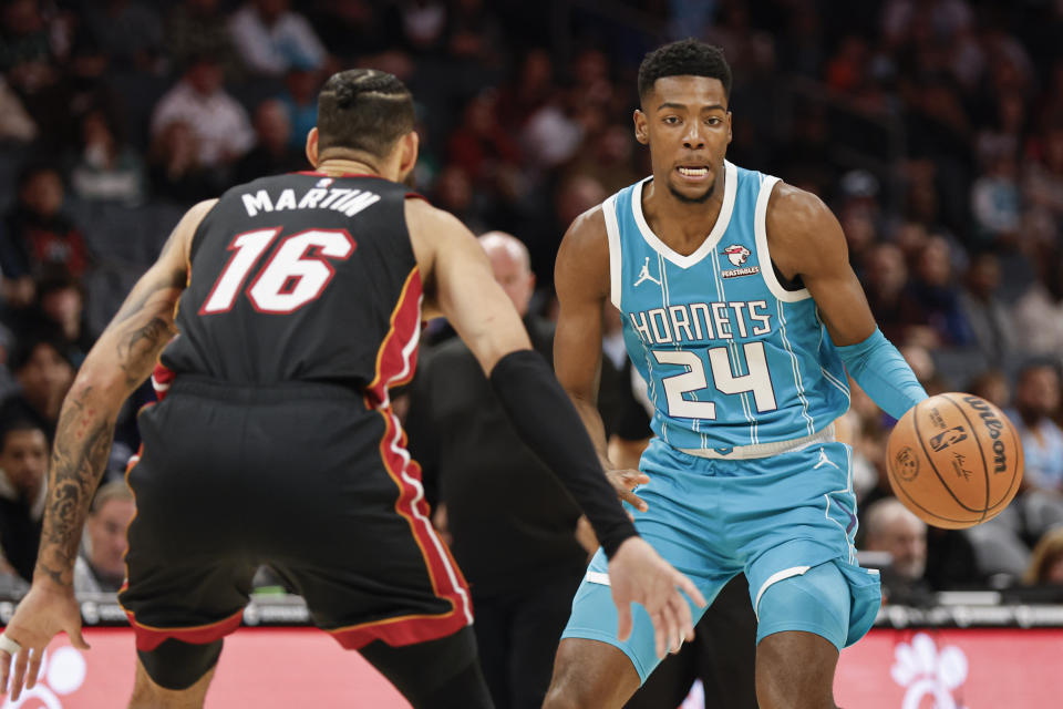 Charlotte Hornets forward Brandon Miller (24) looks to drive against Miami Heat forward Caleb Martin during the first half of an NBA basketball game in Charlotte, N.C., Monday, Dec. 11, 2023. (AP Photo/Nell Redmond)