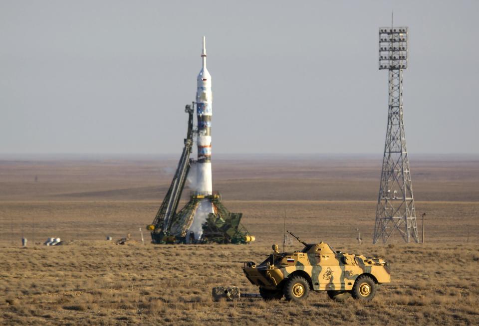 An armoured security vehicle is driven in front of the Soyuz TMA-11M spacecraft at the Baikonur cosmodrome