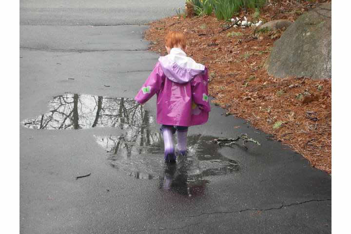Catherine Hubbard, wearing a raincoat and boots, is seen walking along a driveway.