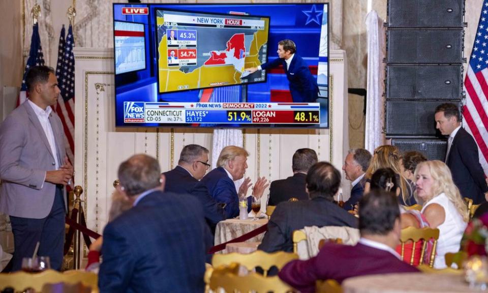 trump at table under screen showing fox news
