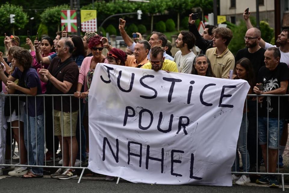 Spectator deploy a banner which reads Justice for Nahel along the race route at the start of the 1st stage of the 110th edition of the Tour de France cycling race 182 km departing and finishing in Bilbao in northern Spain on July 1 2023 Clashes continued across France despite the 45000 police officers deployed the highest number of any night since the start of the protests backed by light armoured vehicles and elite police units Police made more than 1000 arrests and the country braced for more riots ahead of the funeral of the 17yearold teenager who was killed by a police officer during a traffic stop Photo by Marco BERTORELLO  AFP Photo by MARCO BERTORELLOAFP via Getty Images