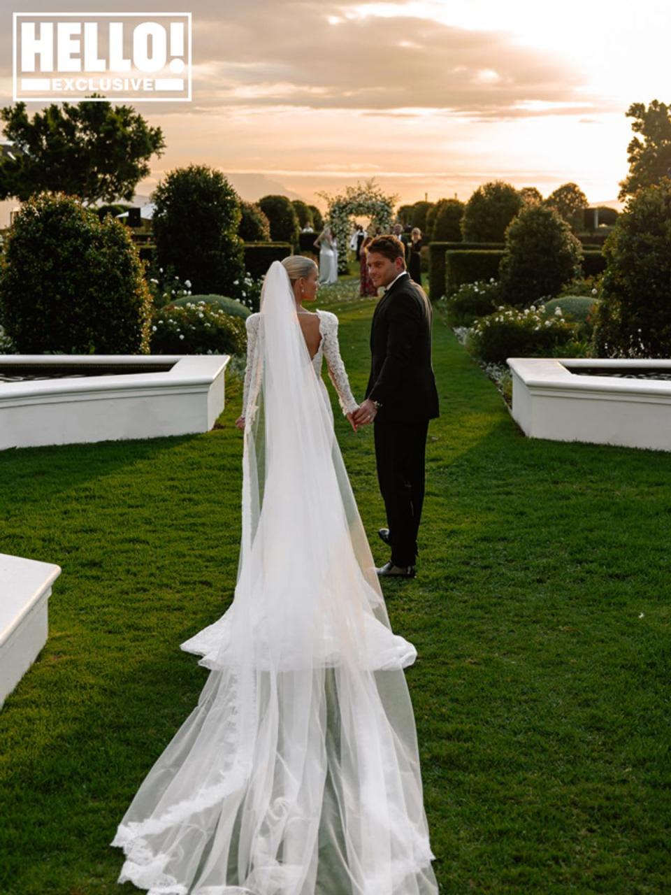 Lady Amelia Spencer with her back to the camera as she holds husband Greg Mallett's hand