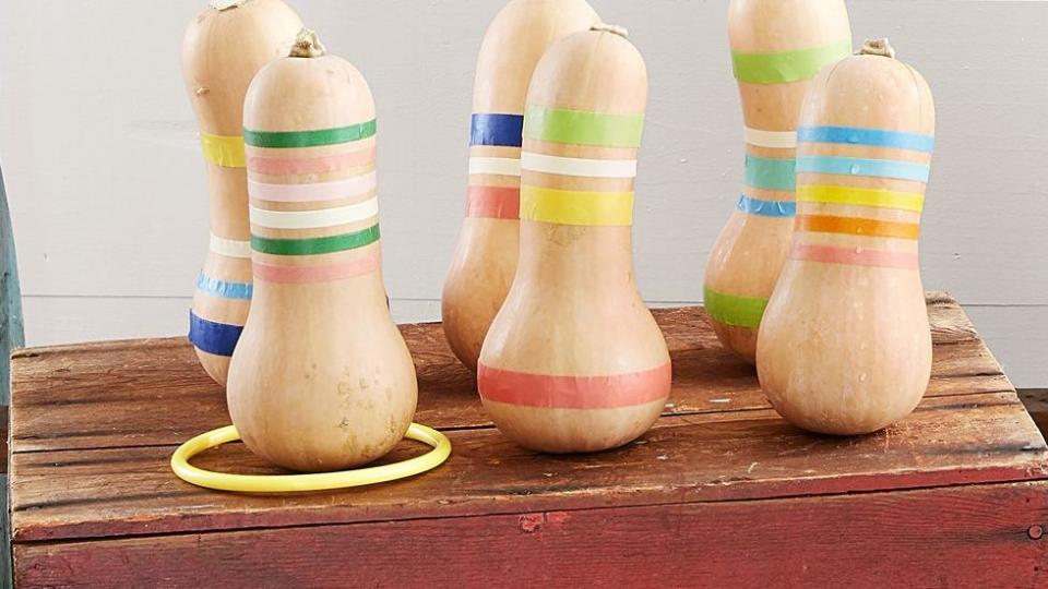 a ring toss carnival like game that is made using butternut squash decorated with rings of colorful washi tape