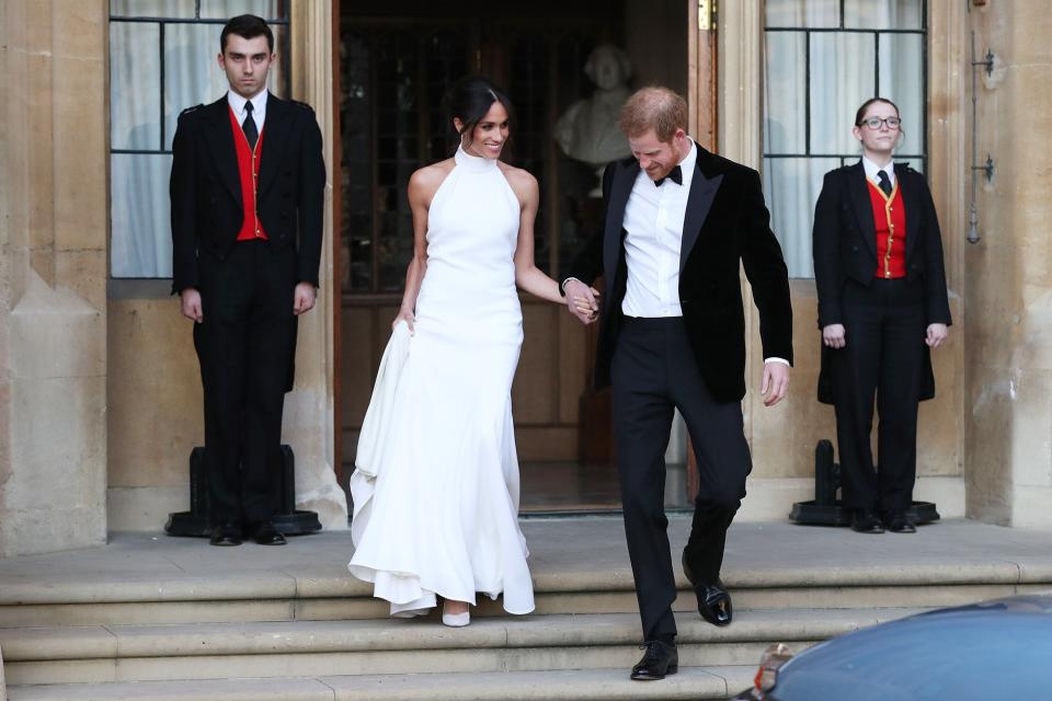 The newly married Britain's Prince Harry, Duke of Sussex, (R) and Meghan Markle, Duchess of Sussex, (L) leave Windsor Castle in Windsor on May 19, 2018 after their wedding to attend an evening reception at Frogmore House.