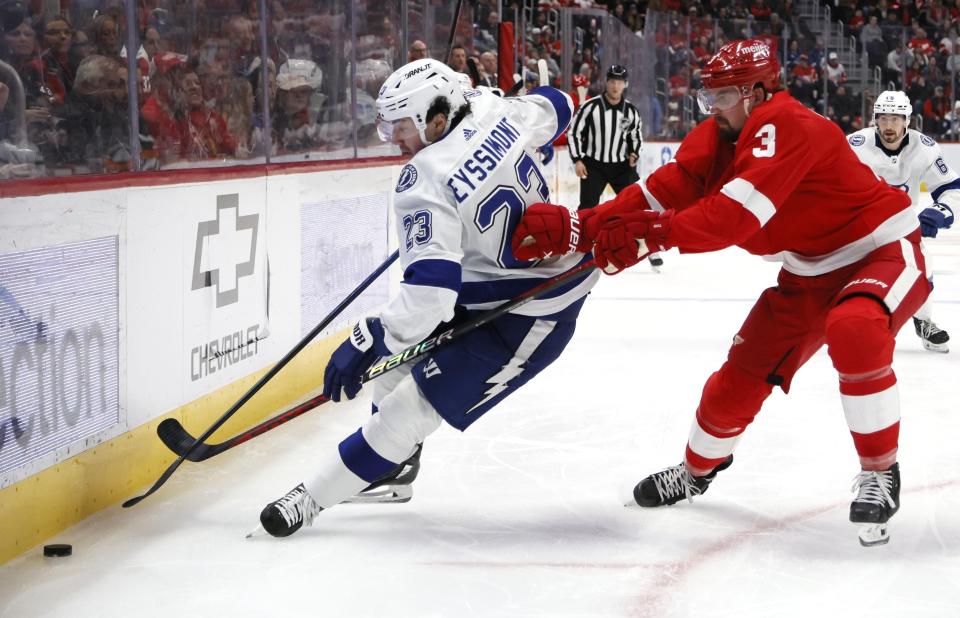 Detroit Red Wings defenseman Justin Holl (3) tries to steal the puck from Tampa Bay Lightning center Michael Eyssimont during the second period of an NHL hockey game, Sunday, Jan. 21, 2024, in Detroit. (AP Photo/Duane Burleson)