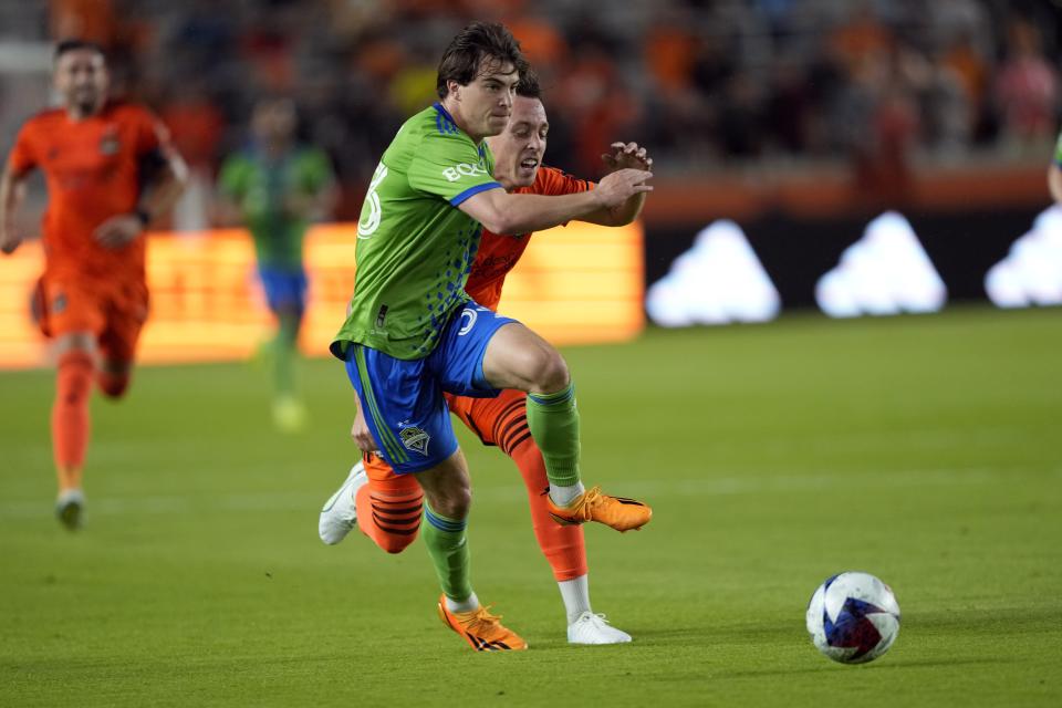 Seattle Sounders' Cody Baker, left, and Houston Dynamo's Corey Baird battle for the ball during the first half of an MLS soccer match Saturday, May 13, 2023, in Houston. (AP Photo/David J. Phillip)