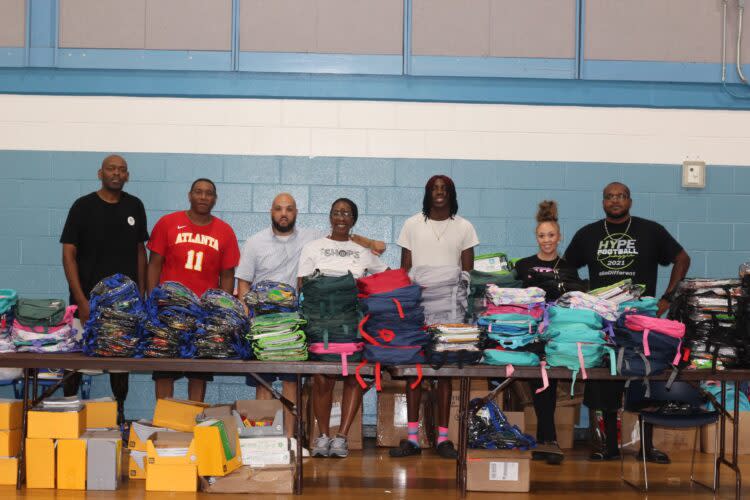 Founder and president of HYPE Pensacola Shaun Hartsfield (third from left) and volunteers gave away over 500 backpacks at their Aug. 5 event. (Ronald Kirkland)